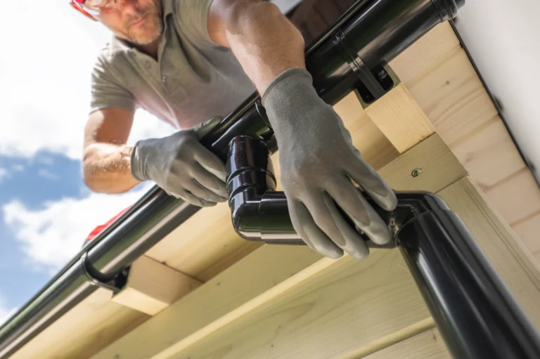 Gutter cleaning contractor working from a ladder on a residential home